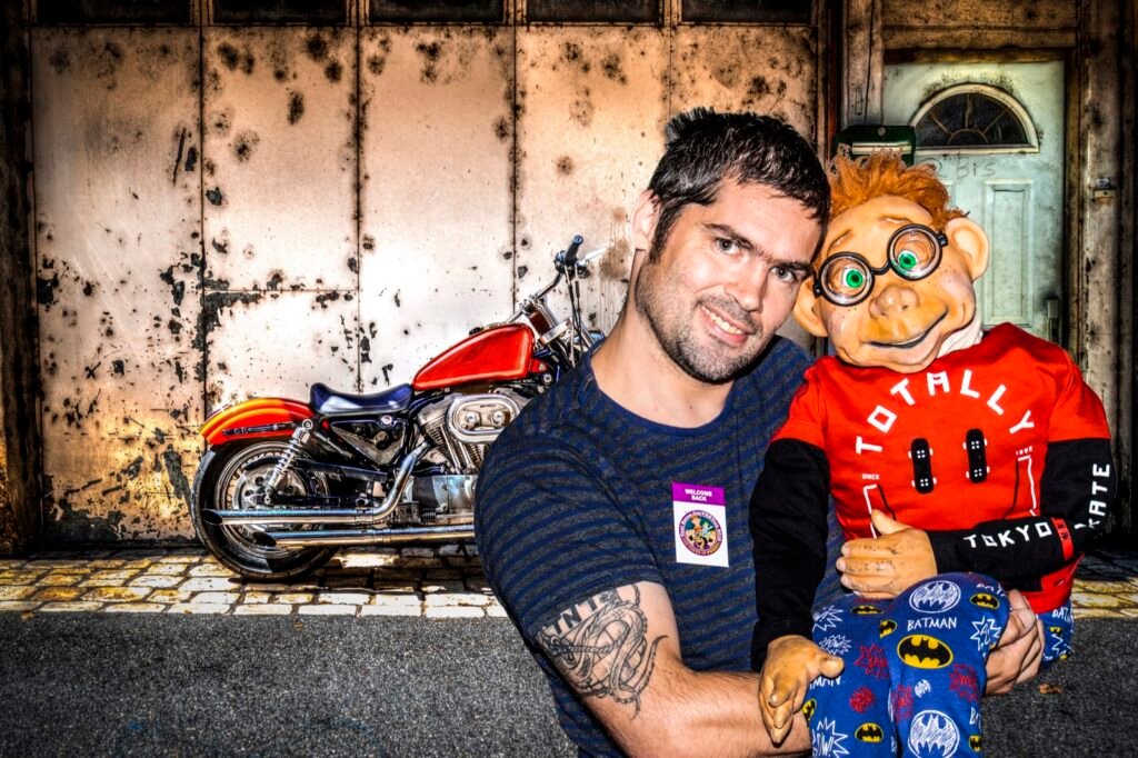 Performer and character posed with a motorcycle in a cinematic garage