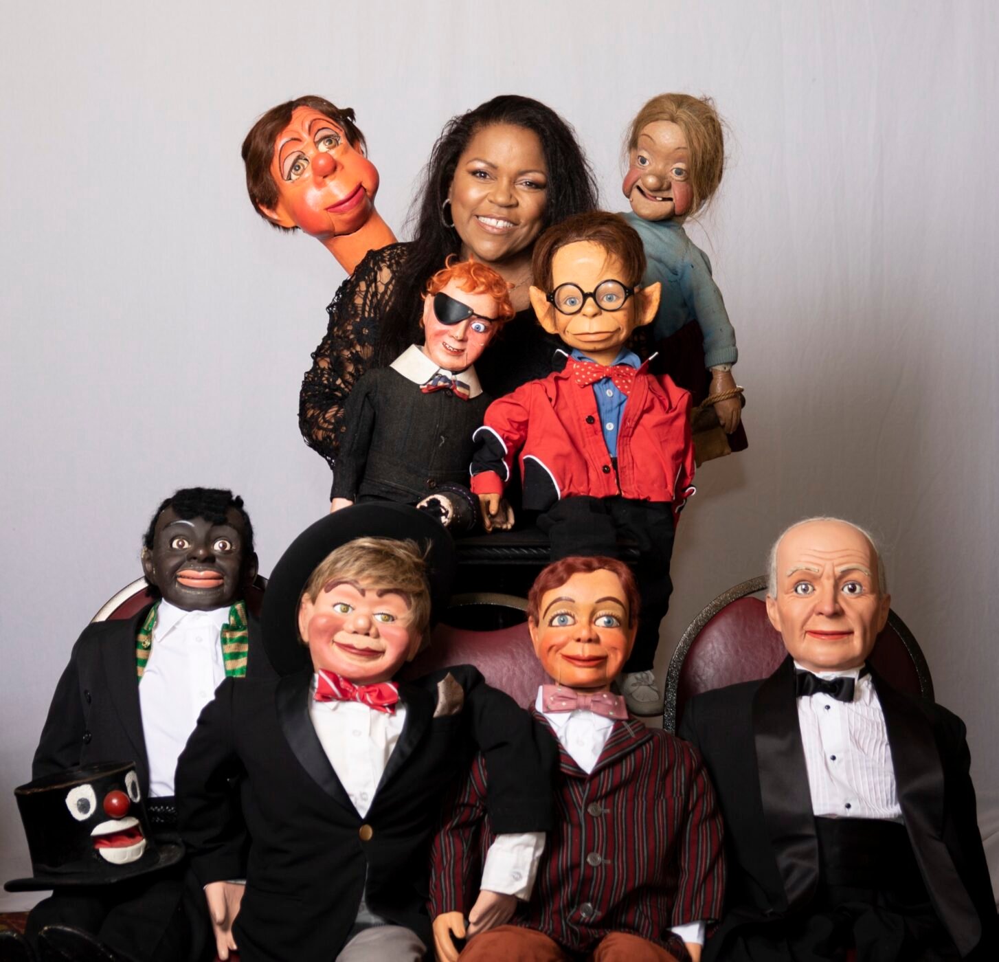 Performer surrounded by a large ensemble of expressive characters
